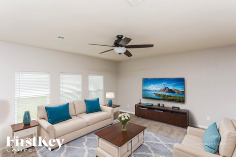 A living room with a white couch, a coffee table, and a painting on the wall.