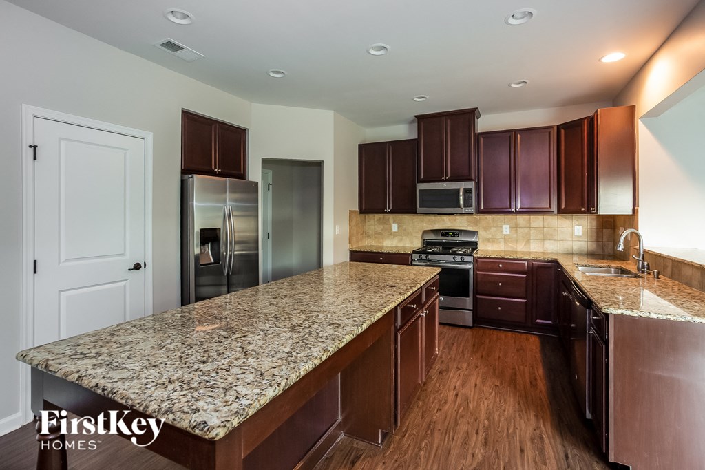 an updated kitchen with granite countertops and stainless steel appliances