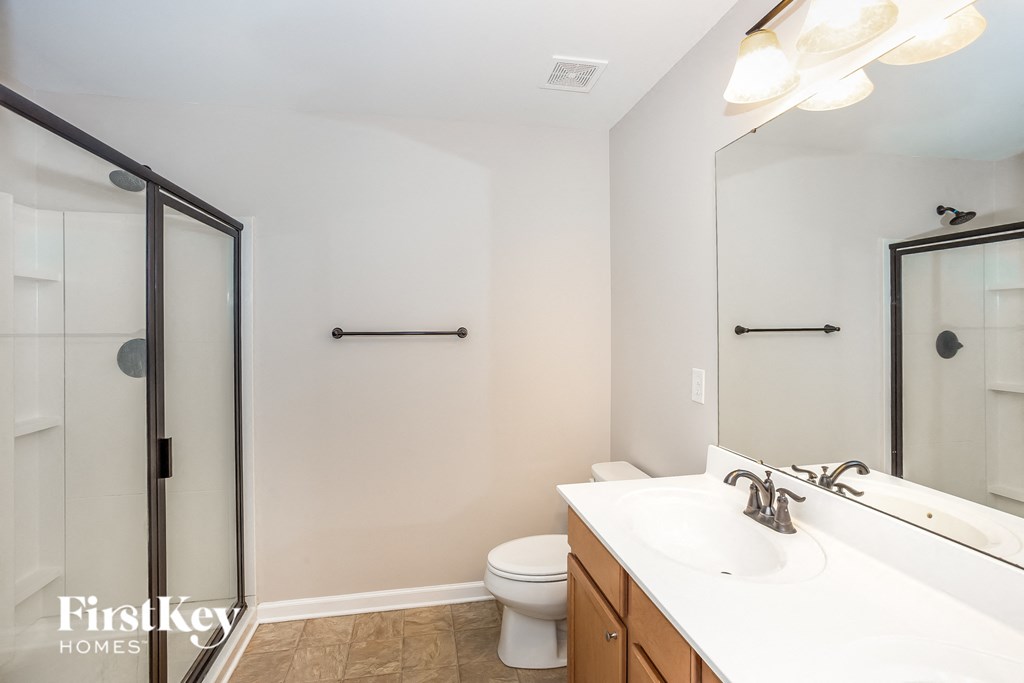 a bathroom with a white sink and a shower and a toilet