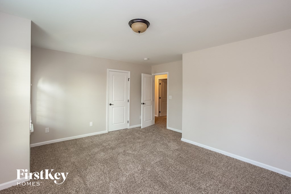 a master bedroom with carpeted flooring and white walls