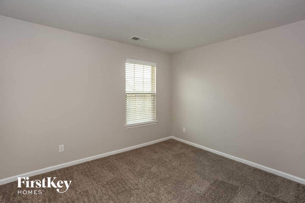 a empty room with carpet and a window