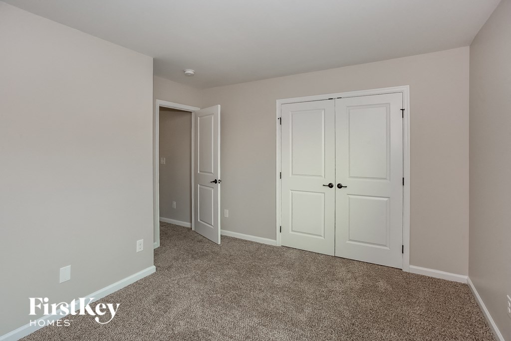 a bedroom with two closets and a carpeted floor