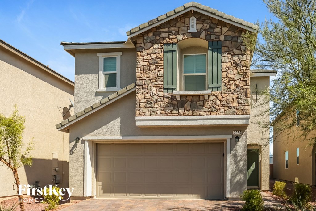 A house with a stone facade and a garage door.