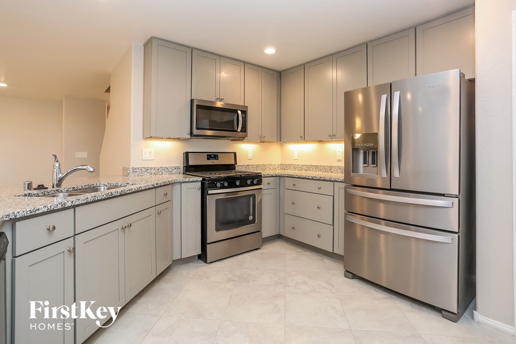 A kitchen with a stainless steel refrigerator and oven.