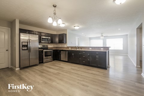 a large kitchen with stainless steel appliances and wood flooring
