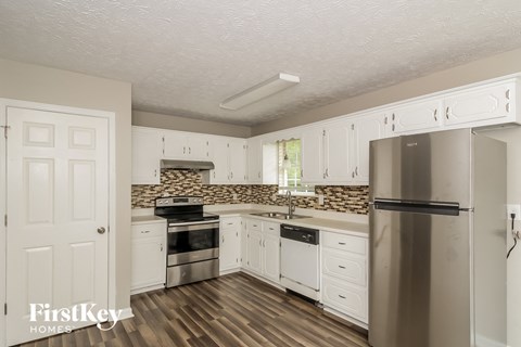 A kitchen with a stove top oven and a refrigerator.