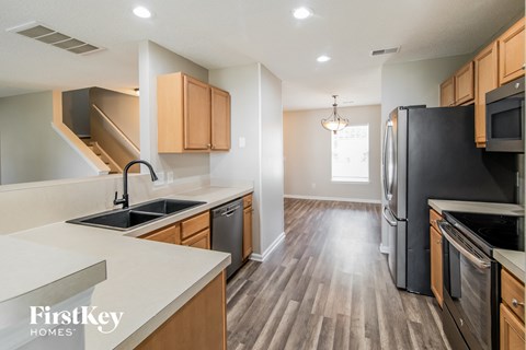 A kitchen with wooden cabinets and black appliances.