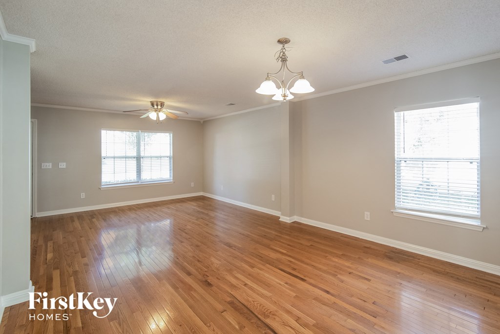 A room with wooden floors and a chandelier.