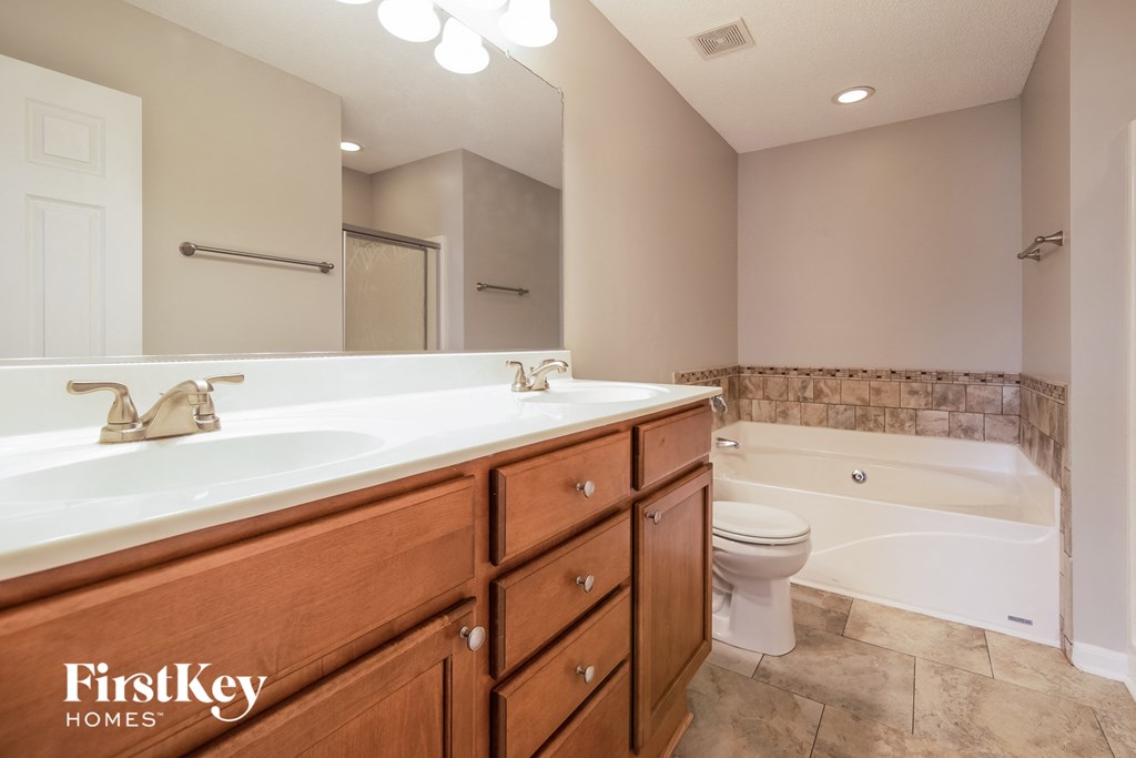 A bathroom with a tub, toilet and sink.