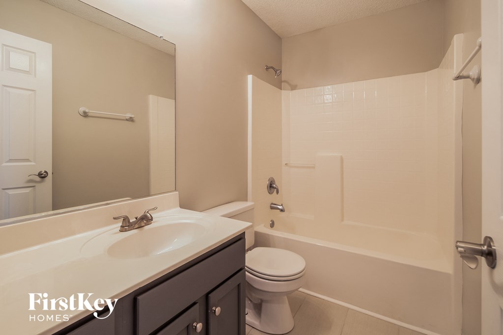 A bathroom with a white sink and toilet.