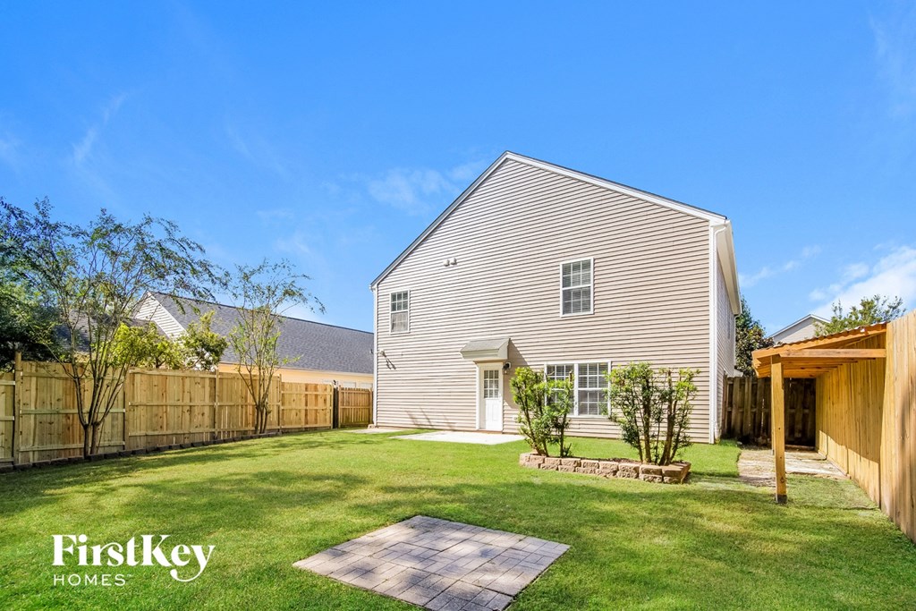 A house with a fence and a small garden in front.