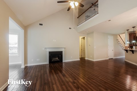 an empty living room with a fireplace and a staircase