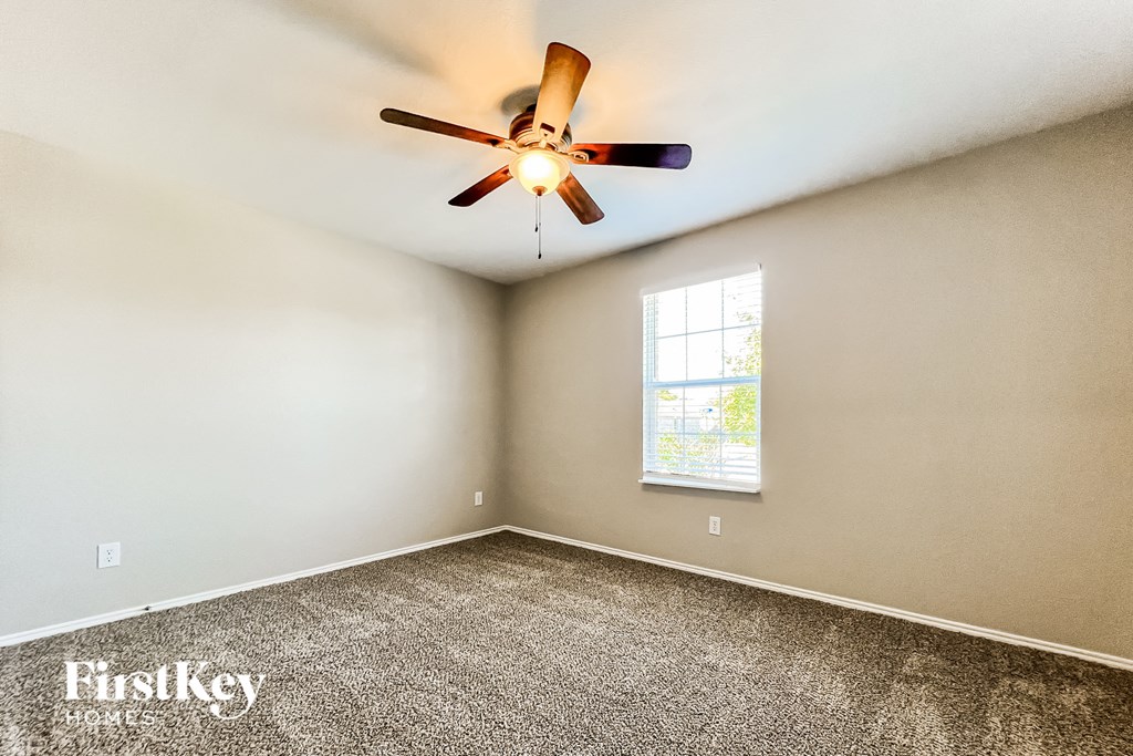 the master bedroom has a carpeted floor and a ceiling fan