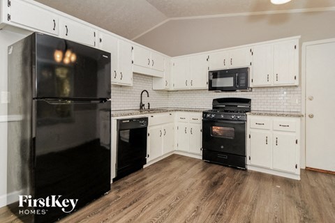 a kitchen with black appliances and white cabinets
