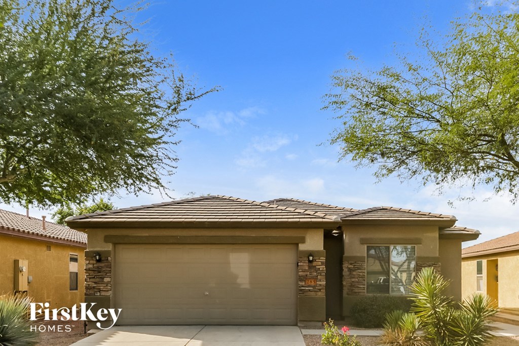A house with a brown roof and a garage door is for sale.