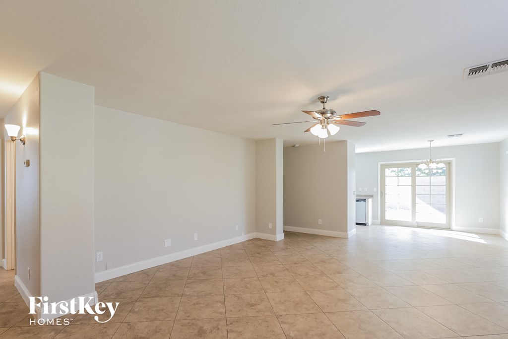 A spacious room with a ceiling fan and tiled floor.