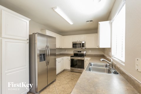 A kitchen with a stainless steel refrigerator and a sink.