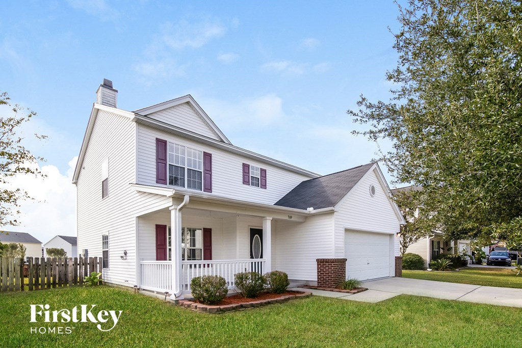 a white house with red shutters and a lawn