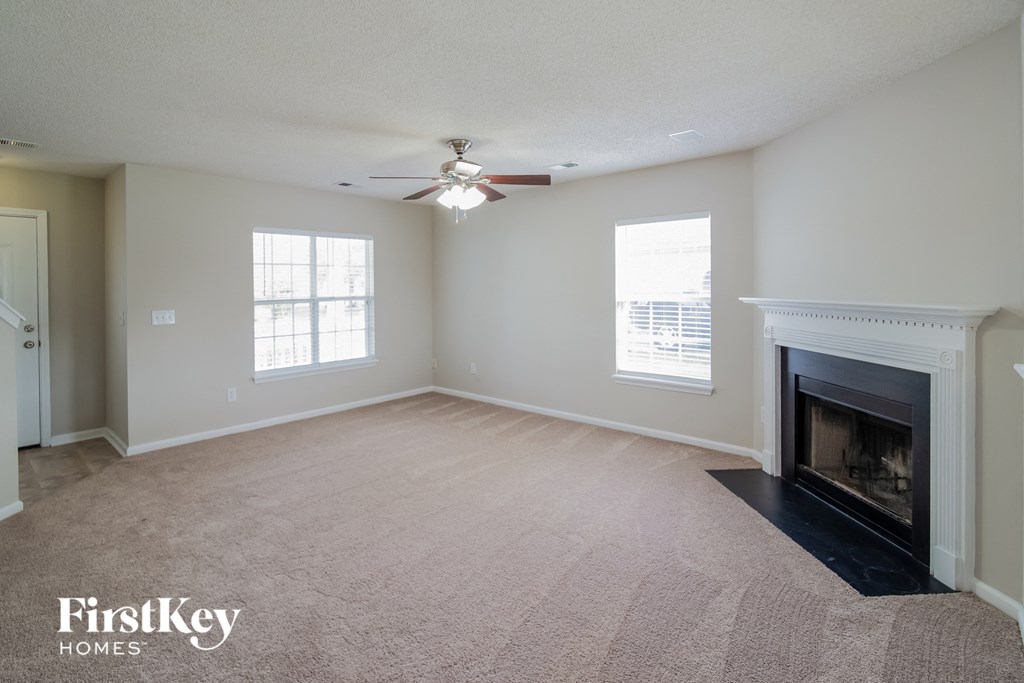 a living room with a fireplace and a ceiling fan