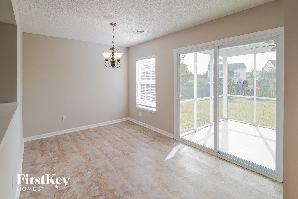 an empty living room with a patio door and a window