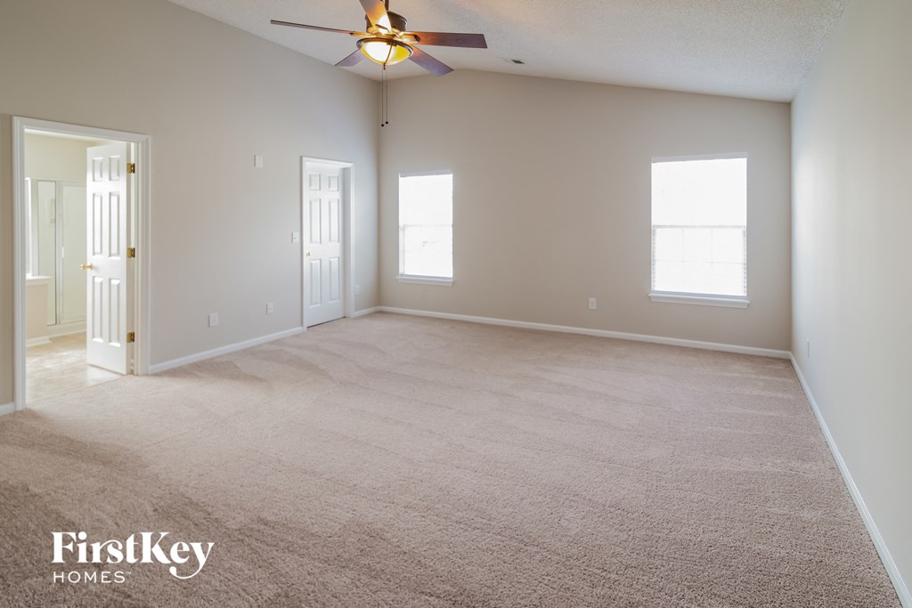 the living room of an empty house with a ceiling fan