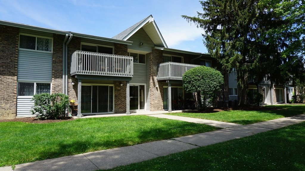 an apartment building with a sidewalk in front of it