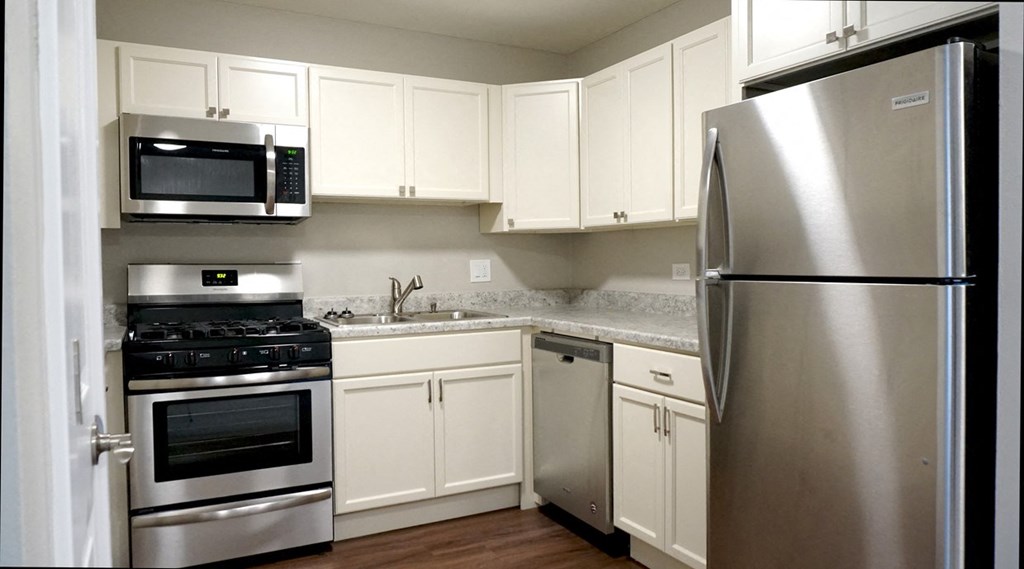 a kitchen with stainless steel appliances and white cabinets