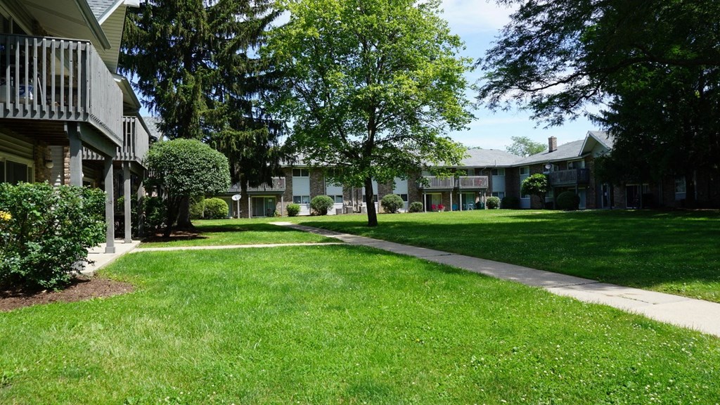 a green lawn in front of a row of houses