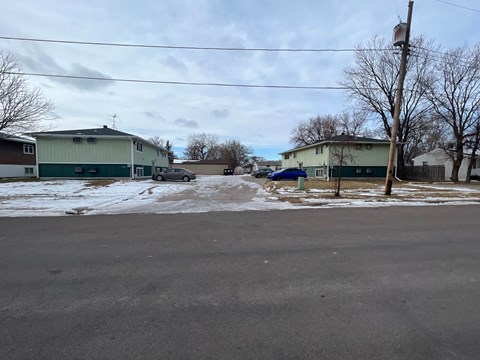 A street view with houses and a car on the road.