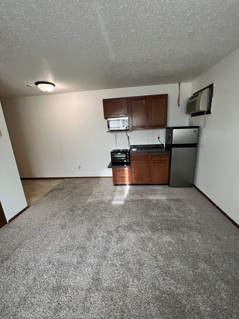 A kitchen area with a refrigerator, microwave, and oven.