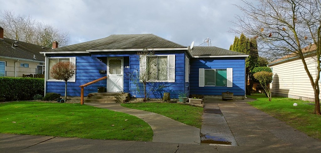 a blue house with a sidewalk in front of it