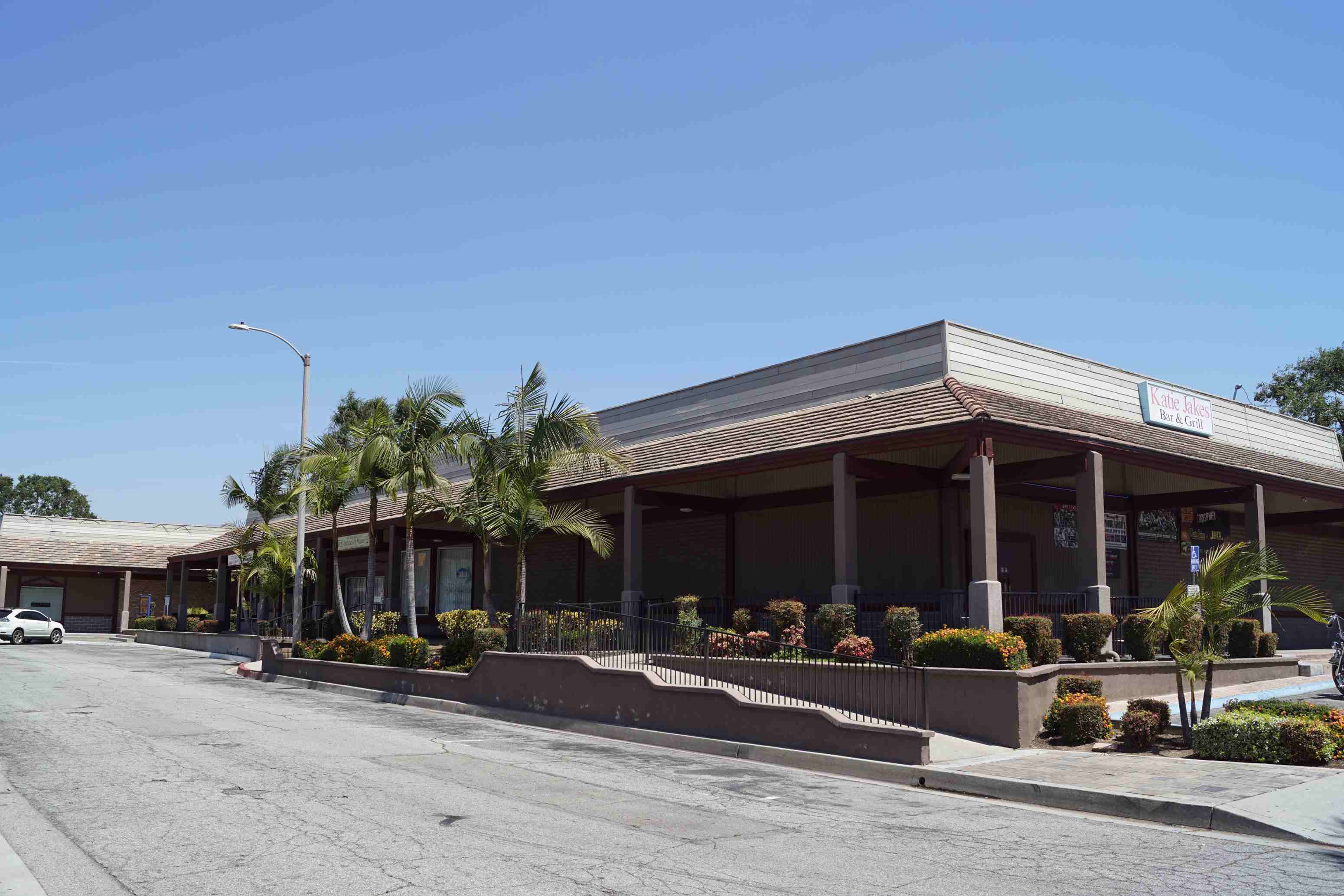 a building with palm trees and a street in front of it