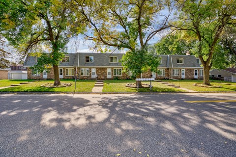a house with trees in front of it on a street