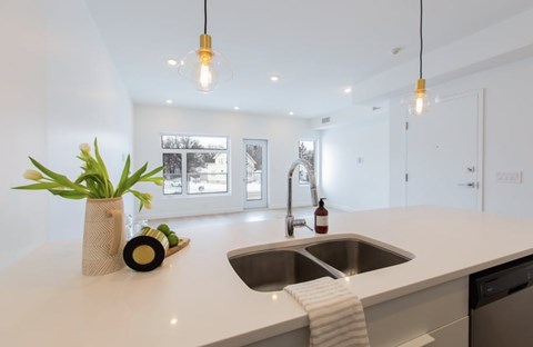 A kitchen with a white countertop and a sink.