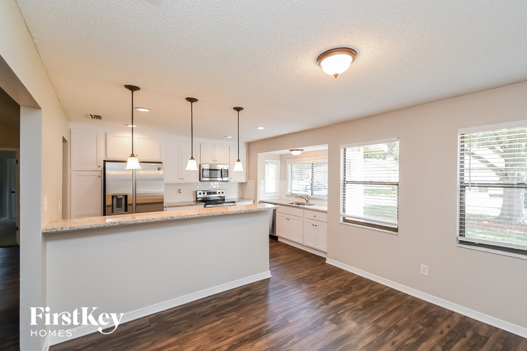 A kitchen with wooden floors and white walls.
