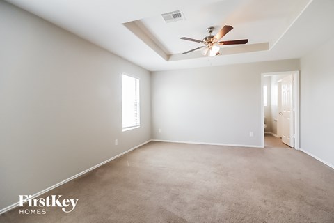 a living room with a ceiling fan and a carpet