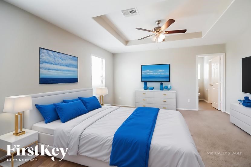 A bedroom with a large bed and a ceiling fan.