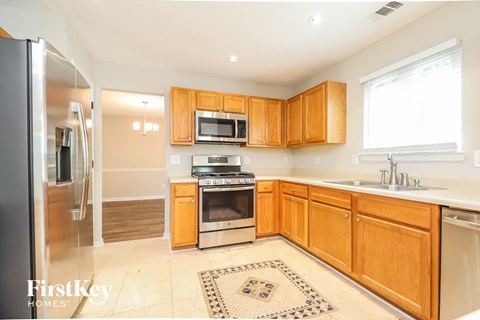 A kitchen with wooden cabinets and a stainless steel refrigerator.