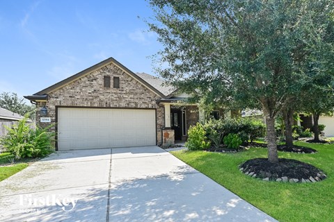 a home with a white garage door and a tree in front of it