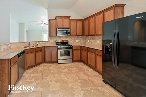 a kitchen with wooden cabinets and stainless steel appliances