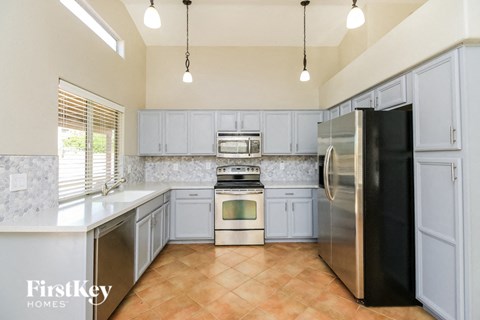 A kitchen with a black refrigerator and stainless steel appliances.