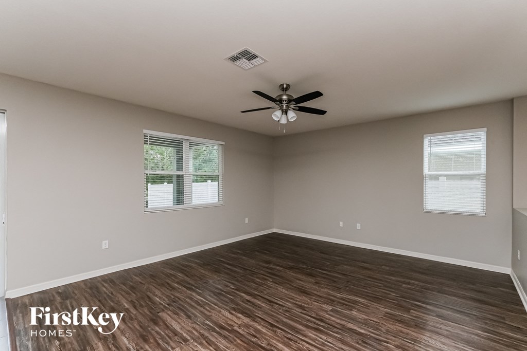 A room with wooden flooring and a ceiling fan.