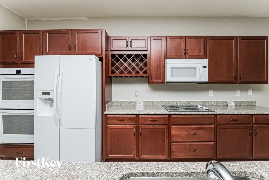 A kitchen with brown cabinets and a white fridge.