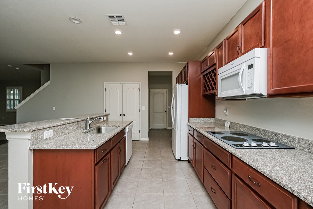 A kitchen with brown cabinets and a white fridge.