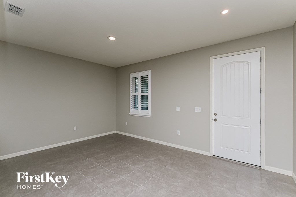 A room with a white door and a window with blinds.