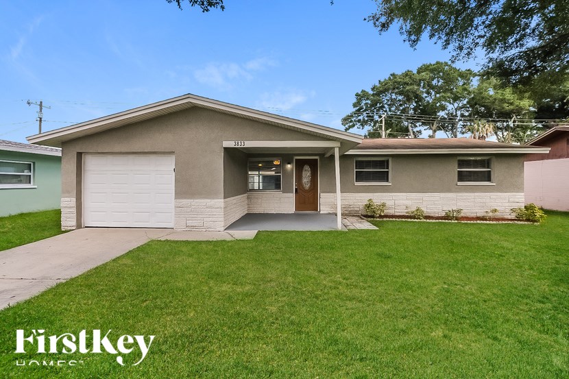A house with a brown door and a garage door is for sale.