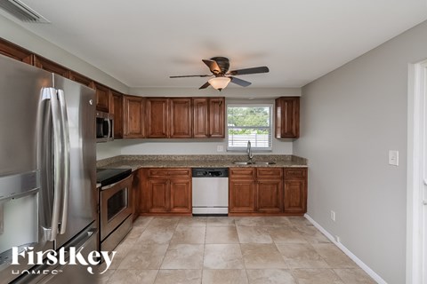 A kitchen with a stainless steel refrigerator and wooden cabinets.