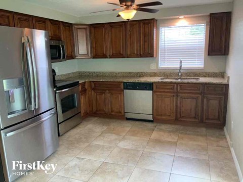 A kitchen with wooden cabinets and a stainless steel refrigerator.