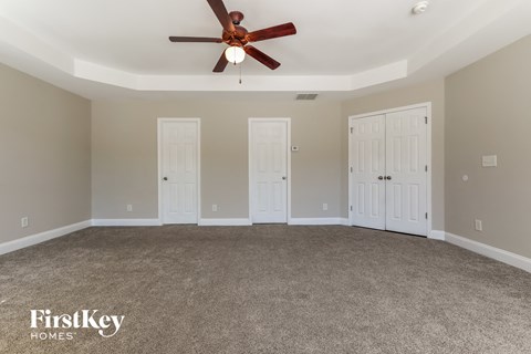 a living room with carpet and a ceiling fan