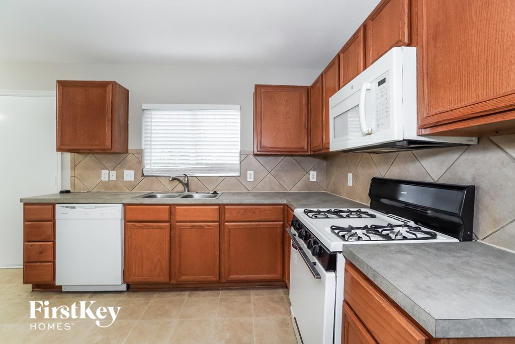 a kitchen with white appliances and wooden cabinets